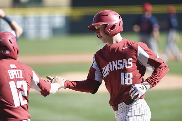 Arkansas outfielder Heston Kjerstad (18) is greeted at home plate by catcher Casey Opitz (12) during a game against South Alabama on Saturday, March 7, 2020, in Fayetteville. 