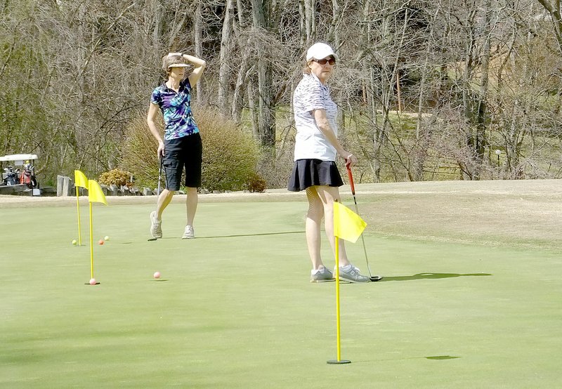 Lynn Atkins/The Weekly Vista Dorie Clements and Stephanie Bryant watch a putt traveling across the practice greens at the Country Club on Thursday.