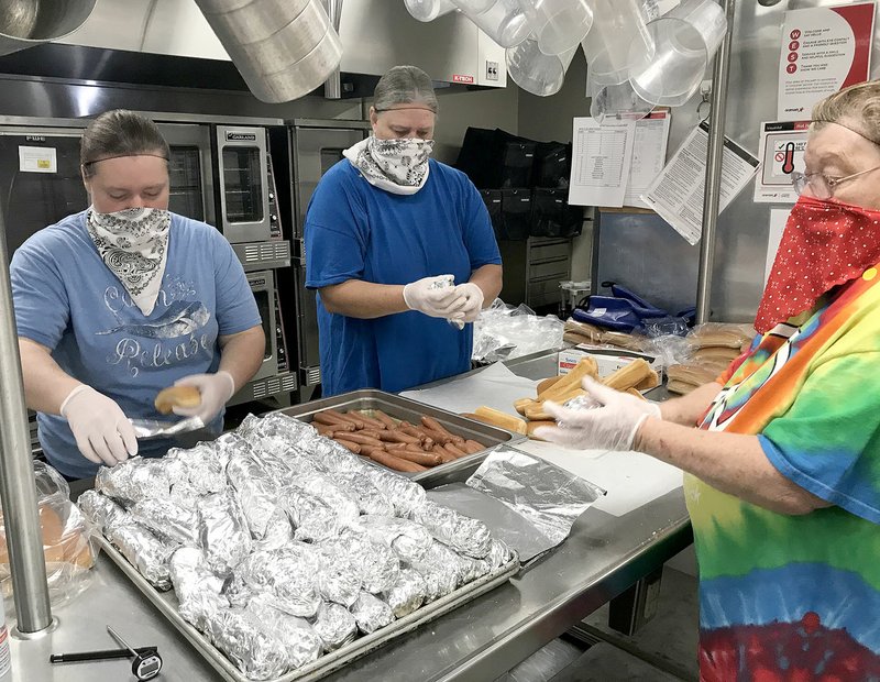 COURTESY PHOTO Aramark employees Melissa Rochier, Toni Walton and Sandy Shepherd, donning bandana facemasks, prepare meals to be delivered to Lincoln students last week. School officials decided to deliver meals while students are on spring break and will continue delivering meals while schools remain closed for in-school instruction because of the covid-19 health crisis.
