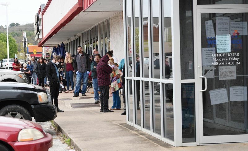 A line of around fifty people extends from the door of Arkansas Workforce Center Monday in Fayetteville. For information about small business loans and applying for Arkansas, unemployment benefits go to www.arkansasedc.com/covid19. For daily photo galleries visit nwaonline.com/200320Daily/. 
(NWA Democrat-Gazette/J.T.WAMPLER) 