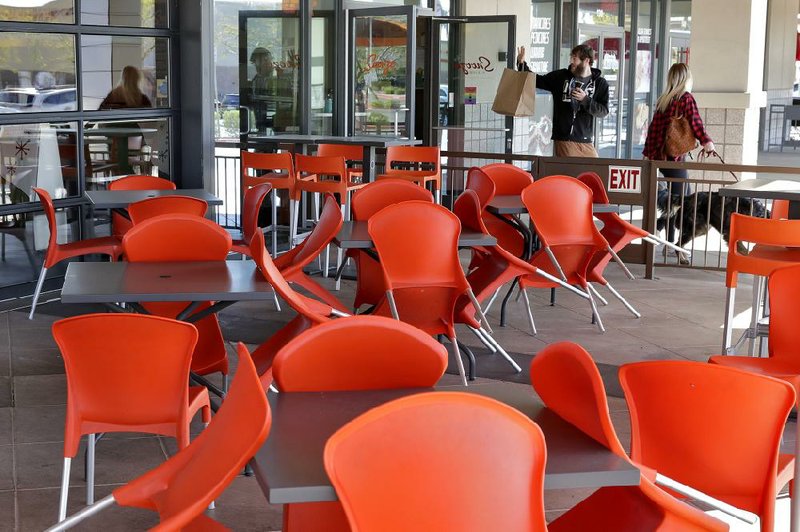 A couple waves Friday after picking up a takeout order at a restaurant in Phoenix. Payroll processor ADP said small businesses took a hit in March losing 90,000 jobs.
(AP/Matt York)