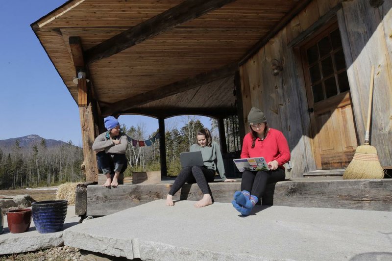 Ashley Bullard (from left) sits on the porch of her family’s rural home in North Sandwich, N.H., as her daughters Raven, a high school senior, and Willow, a college freshman, do classwork from home last week. 
(AP/Charles Krupa)