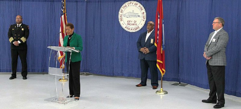 Pine Bluff Fire Chief Shauwn Howell (from left), Mayor Shirley Washington, Police Chief Kelvin Sergeant, and Jefferson Regional Medical Center CEO Brian Thomas stand in a wide semicircle during a news conference Tuesday at the Pine Bluff Convention Center to provide updates on the covid-19 pandemic. Attendance was limited to city officials and media representatives. The news conference was live-streamed on the city’s Facebook page. 
(Arkansas Democrat-Gazette/Dale Ellis) 
