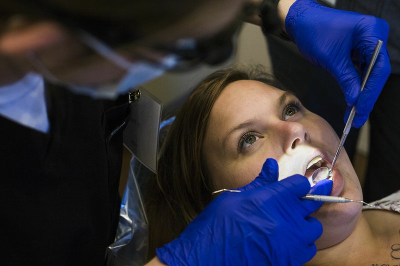 FILE -- Dr. Daniel Fish examines the teeth of Kayse Cartwright of Springdale, Saturday, June 16, 2018 at Welcome Health in Fayetteville. (NWA Democrat-Gazette/CHARLIE KAIJO)