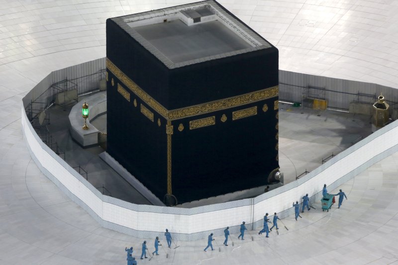 Workers disinfect the ground around the Kaaba, the cubic building at the Grand Mosque, in the Muslim holy city of Mecca, Saudi Arabia, Saturday, March 7, 2020. Saudi Arabia emptied Islam's holiest site for what they say sterilization over fears of the new coronavirus. (AP Photo/Amr Nabil)