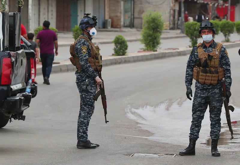 Security forces are deployed to enforce a curfew to help fight the spread of the coronavirus. in central Baghdad, Iraq, Tuesday, March 31, 2020. The new coronavirus causes mild or moderate symptoms for most people, but for some, especially older adults and people with existing health problems, it can cause more severe illness or death. (AP Photo/Hadi Mizban)