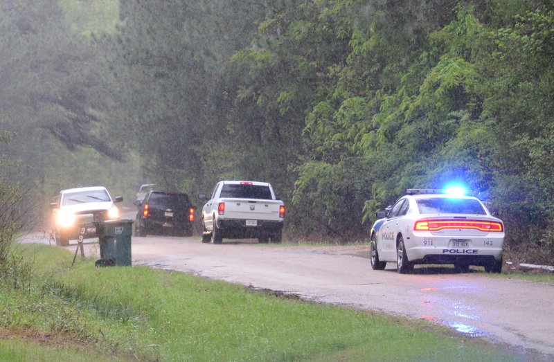 Police cars line the road near a mobile home at 105 Columbia Rd. 295 after a March 30 shooting near Magnolia. 