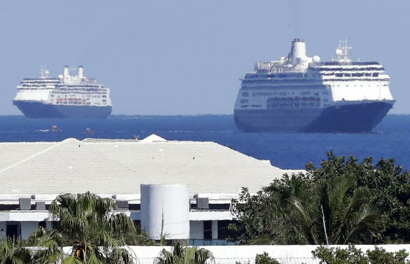 The cruise ships Rotterdam (left) and Zaandam sail toward port Thursday at Fort Lauderdale, Fla., with coronavirus patients aboard after days of negotiations with local, state and federal officials. The Zaandam has been at sea for two weeks after being turned away from South American ports. The agreement allowed for a few of the sickest passengers to be taken to a hospital. More photos at arkansasonline.com/43cruise/.
(AP/Wilfredo Lee)