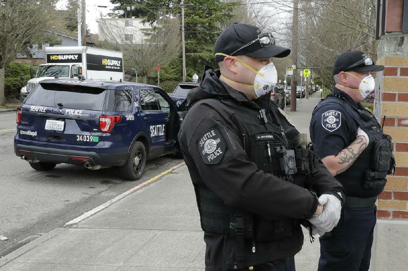 Seattle police officers wear N95 masks for protection against the coronavirus as they patrol Thursday.
(AP/Ted S. Warren)
