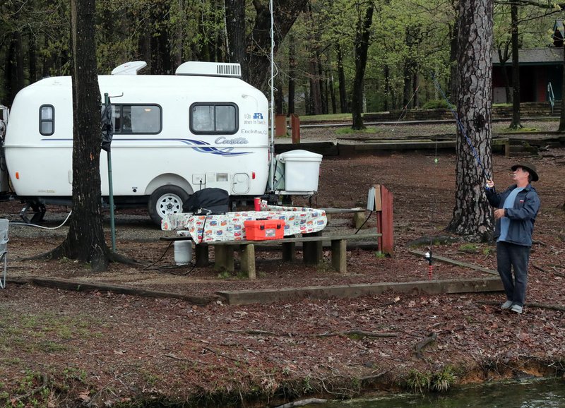 Scott Cordes, of San Diego, Calif., fishes near his camper at Lake Catherine State Park Tuesday, prior to the closure of overnight camping. - Photo by Richard Rasmussen of The Sentinel-Record