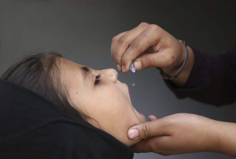 FILE - In this Wednesday, Aug. 8, 2018 file photo, an Afghan health worker gives a vaccination to a child during a polio campaign in the old part of Kabul, Afghanistan. The World Health Organization and partners attempting to eradicate polio say they are being forced to suspend their mass immunization efforts amid the surging coronavirus pandemic. (AP Photo/Rahmat Gul, File)