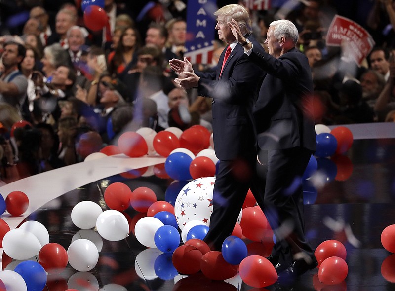In this July 21, 2016, file photo, Republican presidential candidate Donald Trump walks with vice presidential candidate Gov. Mike Pence of Indiana as confetti and balloons fall during celebrations after Trump's acceptance speech on the final day of the Republican National Convention in Cleveland. (AP Photo/Matt Rourke, File)
