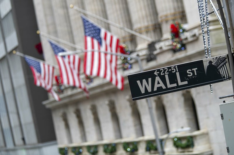 FILE - In this Jan. 3, 2020 file photo, the Wall St. street sign is framed by U.S. flags flying outside the New York Stock Exchange in New York. (AP Photo/Mary Altaffer, File)