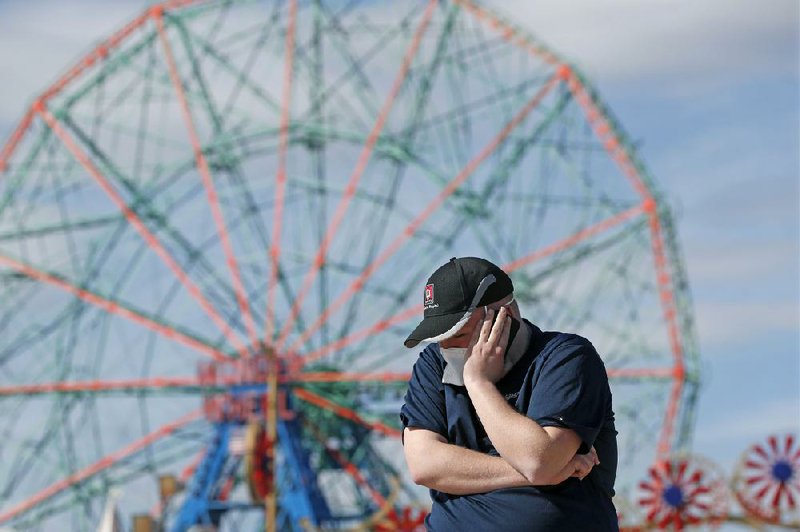 Evan Demaree, a Heartland Disaster Response Team emergency medical services attendant and firefighter from Lafayette, Ind., talks with a friend Thursday at the Coney Island boardwalk in the Brooklyn borough of New York, during a break before the next call for assistance. Demaree’s unit and others like his have been contracted by FEMA to help the New York Fire Department’s overburdened 911 emergency responders.
(AP/Kathy Willens)