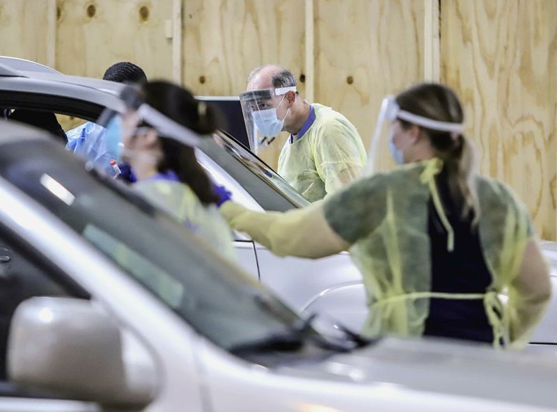 University of Arkansas for Medical Sciences doctors, nurses and technicians check drivers and passengers at a drive-through Covid-19 screening facility, located at the corner of Shuffield and Jack Stephens Drives in Little Rock.
(Arkansas Democrat-Gazette/ John Sykes Jr.)