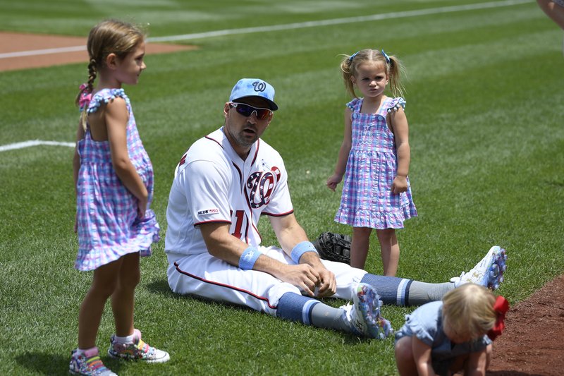 Washington Nationals' Ryan Zimmerman, center, sits on the field with his daughters Mackenzie, left, and Hayden, right, before a baseball game June 16, 2019 against the Arizona Diamondbacks in Washington. With baseball on hold because of the coronavirus pandemic, Zimmerman occasionally will offer his thoughts via diary entries published by the AP, while waiting for the 2020 season to begin. - Photo by Nick Wass of The Associated Press 