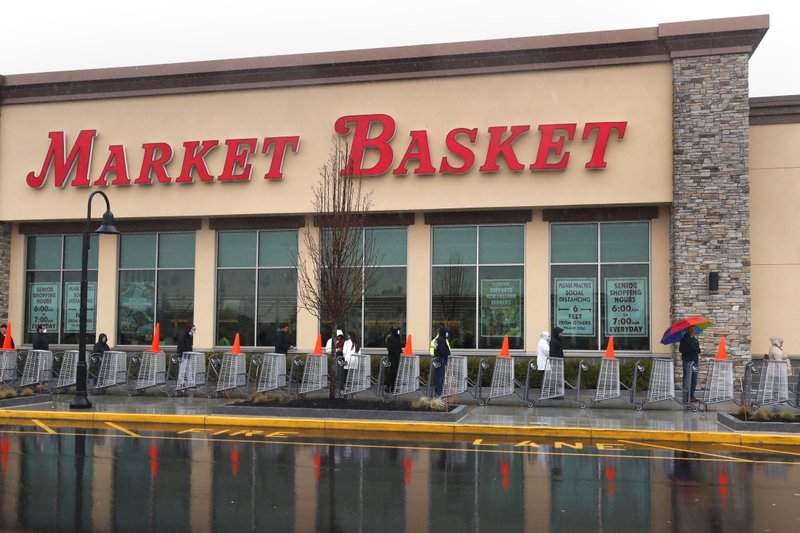 Shoppers wait in line as customer capacity is limited due to the virus outbreak at the Market Basket store in Salem, N.H., on Friday. -AP Photo/Charles Krupa