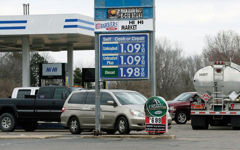 Vehicles line up for lower priced gasoline Thursday in Lakeville, Minn., with reports of some stations selling gasoline for under $1 a gallon as oil prices have dropped. The average price Friday in Arkansas was $1.68, according to travel club AAA.
(AP/Jim Mone)