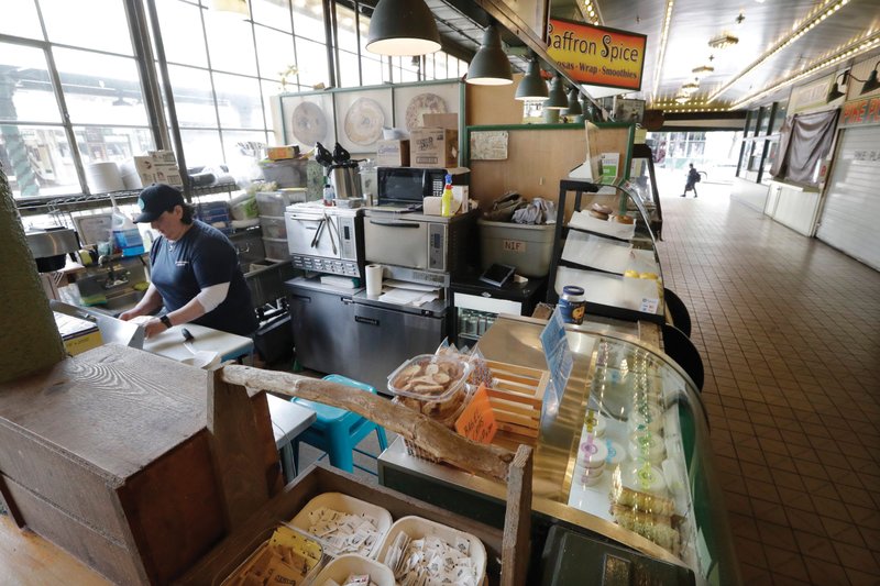 Bagel shop manager Samantha Maddocks works this week at one of the few shops open in the Pike Place Market in Seattle.
(AP/Elaine Thompson)