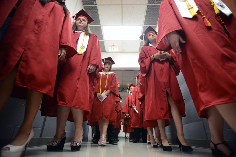 FILE -- Springdale High School graduates walk out in pairs Saturday, May 17, 2014, at Bud Walton Arena in Fayetteville. (NWA Democrat-Gazette/SAMANTHA BAKER)