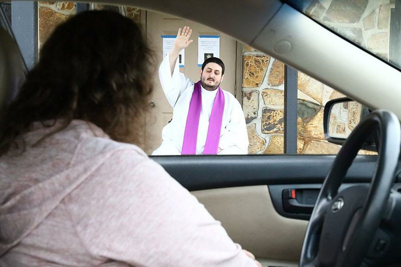 Parishioner and church staffer Belinda Ortner reaches the front of the line at St. Anne Catholic Church’s drive-thru confessional manned by Father Alejandro Puello, pastor of the North Little Rock church.
(Special to the Democrat-Gazette/Dwain Hebda)