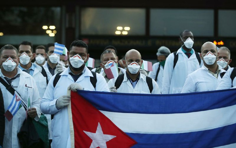 Cuban medical professionals arrive last month at Malpensa airport in Milan, Italy, to help treat covid-19 patients. More photos at arkansasonline.com/44cuba/.
(AP/Antonio Calanni)