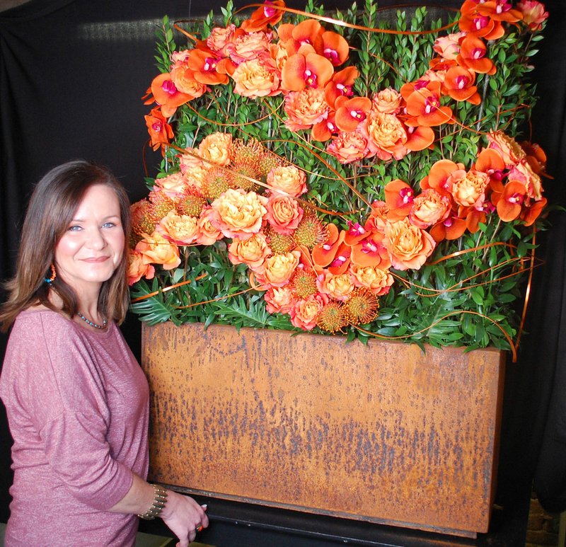 Janelle Jessen/Siloam Sunday Melanie Pentecost, owner of Siloam Flowers and Gifts, poses with the arrangement, titled Heartbeat, she created for the Art in Bloom event at Crystal Bridges Museum of American Art. Even though the event was canceled due to coronavirus concerns, Pentecost decided to move forward with the arrangement. It was designed to be displayed with "Wall Drawing 880: Loopy Doopy" by Sol LeWitt.