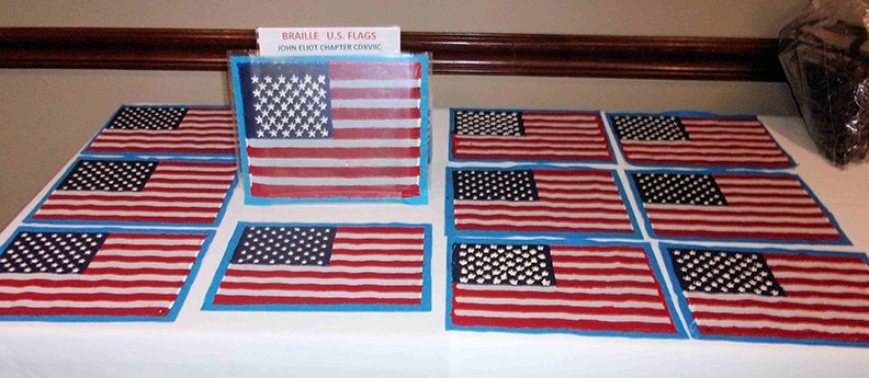 The handcrafted Braille flags are raised so that a student can feel the stars and stripes. - Submitted photo