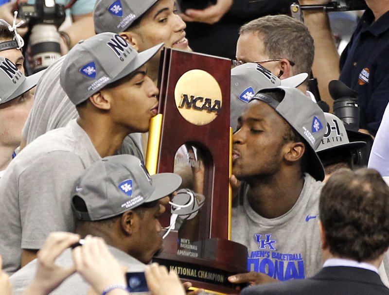 Kentucky forward Anthony Davis, left, and forward Michael Kidd-Gilchrist, right, kiss the trophy after the April 3, 2012, NCAA Final Four tournament championship game against Kansas in New Orleans. Davis had 16 rebounds, six blocks, five assists and three steals in the Wildcats' 67-59 victory over Kansas. His ability to help his team in so many different ways made him one of the best one-and-done players in college basketball history. - Photo by Bill Haber of The Associated Press
