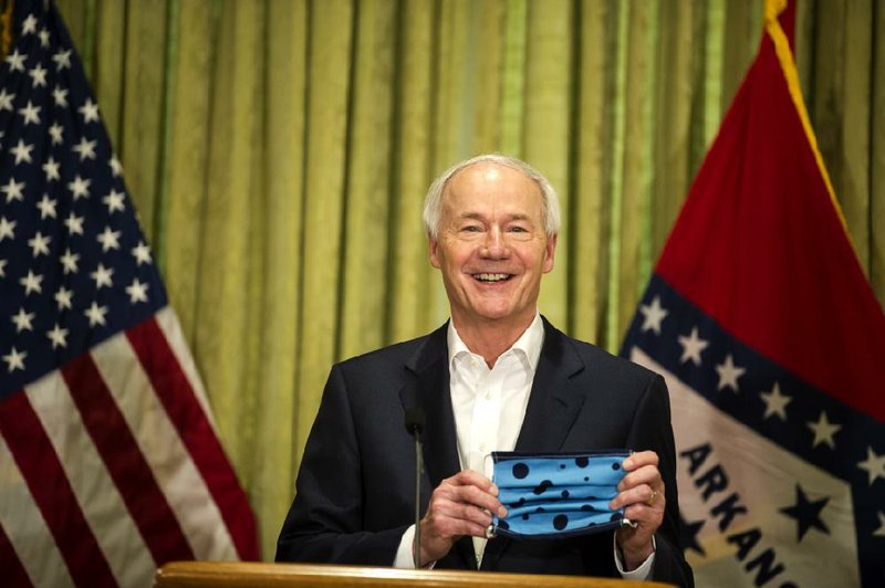 Gov. Asa Hutchinson shows his personal face mask as he delivers a daily update to the media on Arkansas’ covid-19 response Sun- day in the Governor’s Conference Room in the state Capitol. More at arkansasonline.com/46gov/. 
(Arkansas Democrat-Gazette/Steven Swofford)