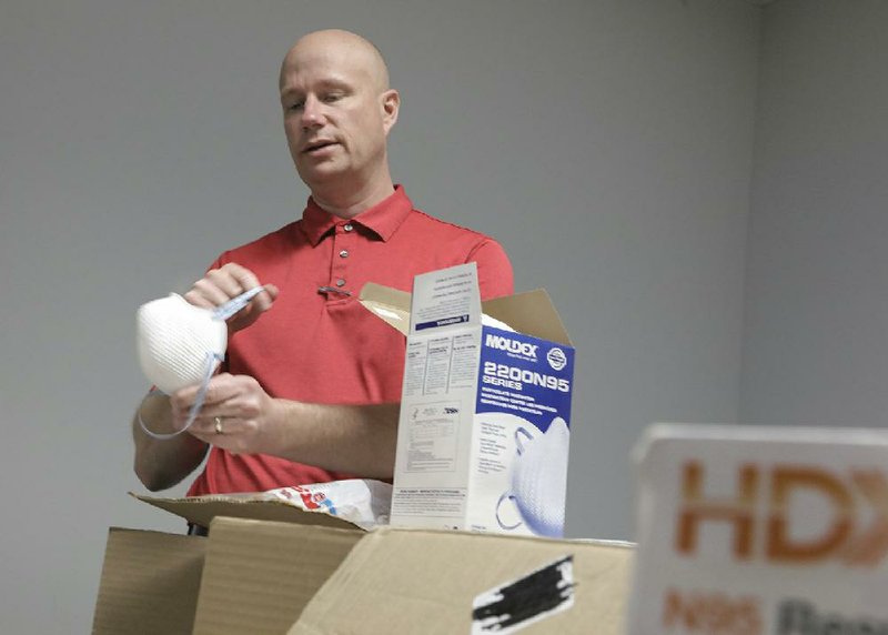 Nathan Spicer, an emergency manager specialist with the Little Rock city manager’s office shows personal protection equipment donated by anonymous contributors Wednesday at the city’s Emergency Operations Center on Murray Street, off 65th Street. (Arkansas Democrat-Gazette/John Sykes Jr.) 