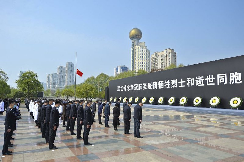 Participants bow Saturday in Wuhan, in central China’s hard-hit Hubei province, during a national moment of mourning for victims of the coronavirus.
(AP/Chinatopix)