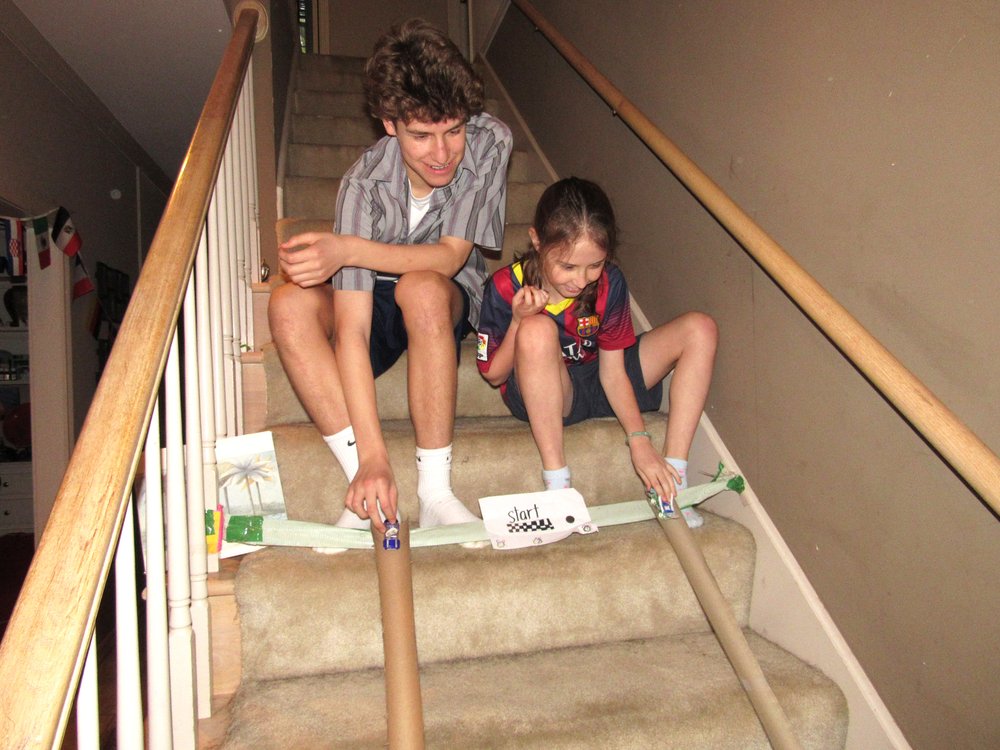 Bennett Dishongh, 15, and 8-year-old Charlie Dishongh stage their own luge races using paper tubes as a track; a project kids can make for entertainment during the covid-19 pandemic. (Special to the Democrat-Gazette/Kimberly Dishongh)