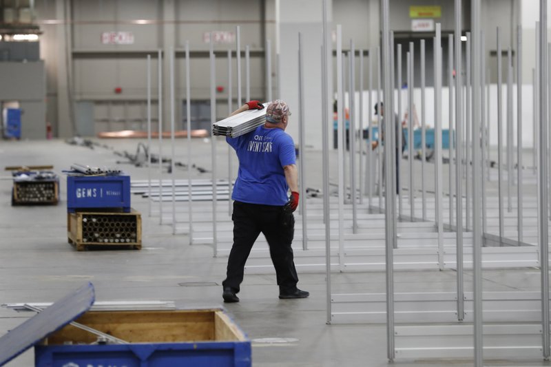 In this April 1 photo, work continues at the TCF Center to build temporary hospital rooms in the convention center in Detroit. In the decade before Michigan and its largest city became the latest hotspot for the deadly coronavirus, officials were steadily cutting back on their first line of defense against pandemics and other health emergencies. Approaching bankruptcy, Detroit disbanded most of its public health department and handed its responsibilities to a private nonprofit. - AP Photo/Carlos Osorio