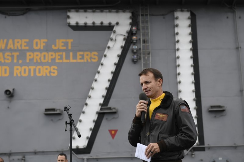 In this Nov. 15, 2019, file photo U.S. Navy Capt. Brett Crozier, commanding officer of the aircraft carrier USS Theodore Roosevelt (CVN 71), addresses the crew during an all-hands call on the ship's flight deck while conducting routine operations in the Eastern Pacific Ocean. U.S. defense leaders are backing the Navy's decision to fire the ship captain who sought help for his coronavirus-stricken aircraft carrier, even as videos showed his sailors cheering him as he walked off the vessel. Videos went viral on social media Friday showing hundreds of sailors gathered on the ship chanting and applauding Navy Capt. Brett Crozier as he walked down the ramp, turned, saluted, waved and got into a waiting car. - U.S. Navy Photo by Mass Communication Specialist 3rd Class Nicholas Huynh via AP