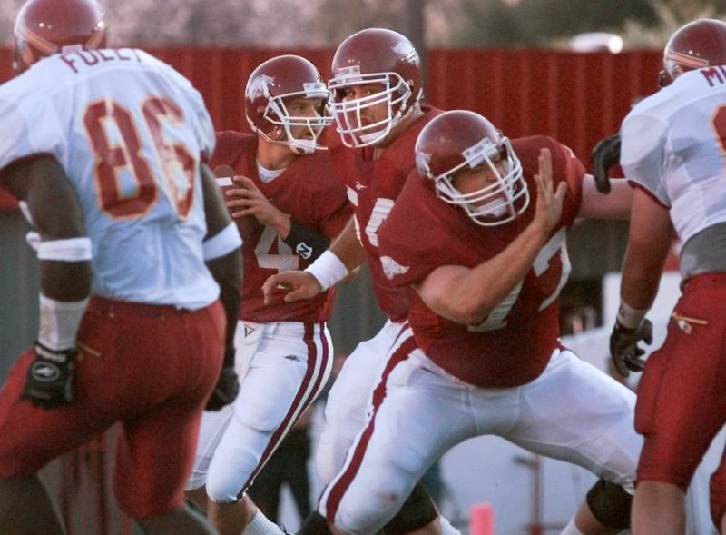 Arkansas offensive linemen Brandon Burlsworth (77) and Grant Garrett (54) form a pocket for quarterback Clint Stoerner during a Sept. 6, 1997, game against Northeast Louisiana in Fayetteville. - NWA Democrat-Gazette file photo