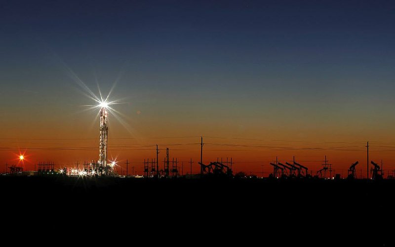 An oil rig is seen at sunset Thursday on the outskirts of Midland, Texas. Oil prices fell Monday after surging last week.
(Odessa American/Eli Hartman)