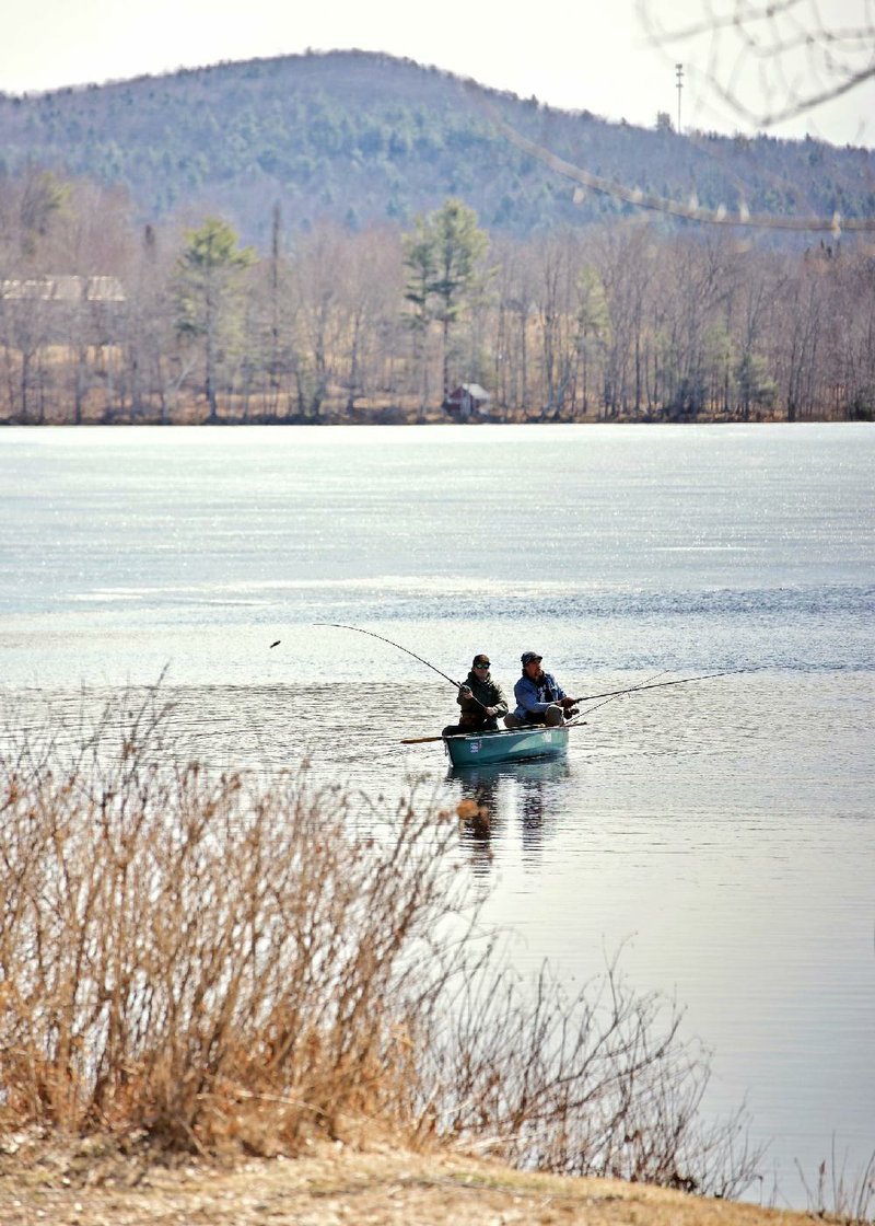 Erick Jones and Owen McMichael go fishing Monday on Pleas- ant Pond in Sumner, Maine. (AP/Sun Journal/Andree Kehn) 
