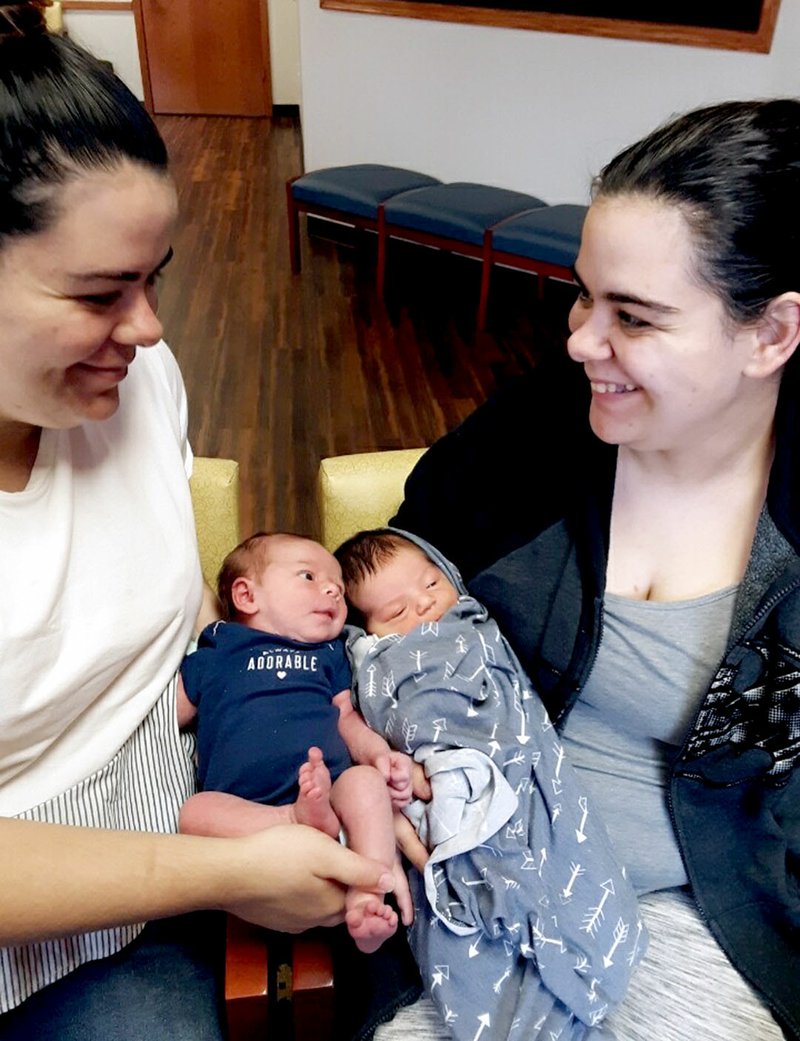 SUBMITTED Identical twins Shiane and Alissa Barnes gave birth just hours apart at Siloam Springs Regional Hospital on March 14. Even though they were in rooms next door to each other, the sisters were unable to see each other or their new niece and nephew at the hospital because of policies put in place to protect patients from the coronavirus. The twins and their infants were united the first time at a doctor's appointment the following week. Pictured are Shiane and her daughter Gypsy River (left) along with Alissa and her son Kenneth Ray.