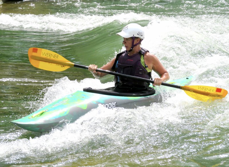 Westside Eagle Observer/RANDY MOLL Lucinda Meglemrie, of Tulsa, Okla., practices her whitewater skills at the Siloam Springs Kayak Park on July 3, 2018. She and her son Zach often make the trip to use the park.