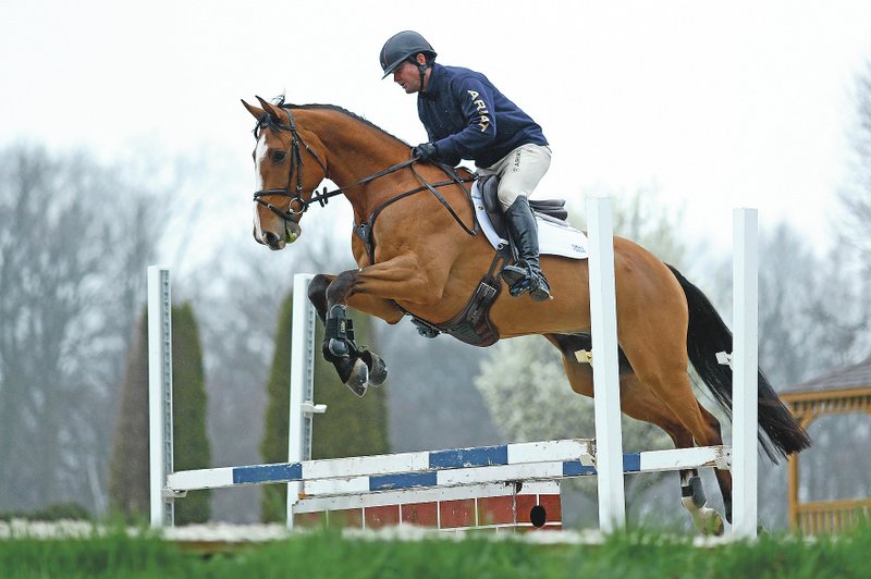 Phillip Dutton, a medal-winning equestrian on the U.S. Olympic team, rides Quasi Cool through a jump during a training session at his farm March 31 in West Grove, Pa. (AP/Matt Slocum)