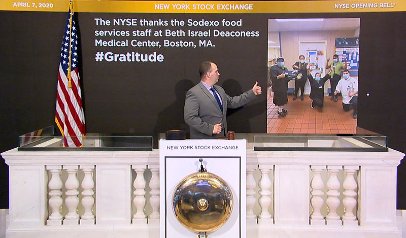 In this image taken from video provided by the New York Stock Exchange, Tommy Gannon, Assistant Supervisor, Facilities, rings the opening bell at the NYSE, and recognizes the Sodexo food services staff at Beth Israel Deaconess Medical Center in Boston, Tuesday, April 7, 2020, in New York. (New York Stock Exchange via AP)