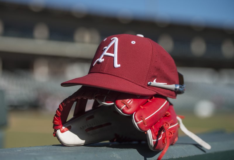 FILE -- A cap and glove rest on the dugout wall Saturday, Jan. 27, 2018, during a scrimmage on Arkansas baseball media day at Baum Stadium in Fayetteville. (NWA Democrat-Gazette/BEN GOFF)