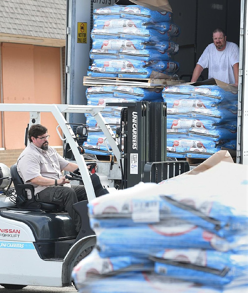 Jimmie Conduff, executive director of Lifesource, unloads pallets of dog food Tuesday, April 7, 2020, for loading onto trailers at the non-profit in Fayetteville. More than 42,000 pounds of dog food was donated by Simmons Foods of Siloam Springs, and coordinated by HARK at Endeavor Foundation for distribution in rural areas of Washington, Benton, Madison and Carol counties. Visit nwaonline.com/2004086Daily/ and nwadg.com/photos for a photo gallery.
(NWA Democrat-Gazette/David Gottschalk)