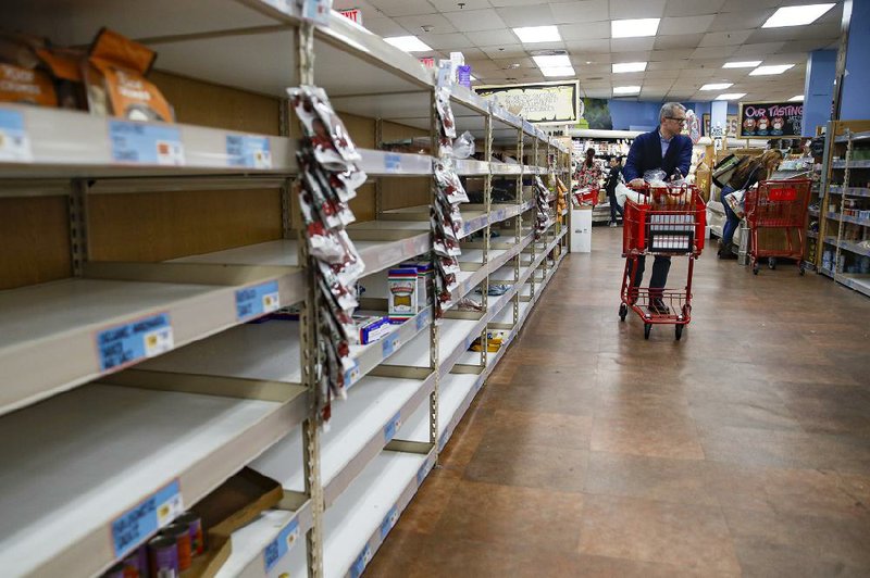 Shoppers browse the nearly empty shelves at a supermarket in Larchmont, N.Y., last month.
(AP/John Minchillo)
