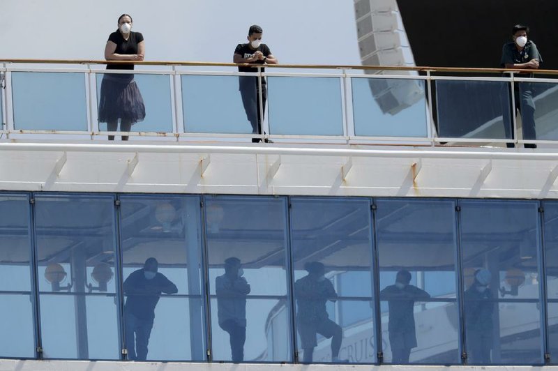 Passengers look out from the Coral Princess cruise ship, docked Saturday at the Port of Miami. As social distancing grew more common as a method to slow the coronavirus, cruises were among the first activities Americans started avoiding. More photos at arkansasonline.com/48ships/.
(AP/Lynne Sladky)