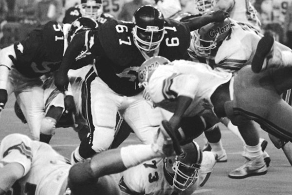 Arkansas defensive lineman Richard Richardson (67) closes in on Florida running back Lorenzo Hampton (7) stretches for a yard in the fourth quarter of the Bluebonnet Bowl game in Houston on Friday, Dec. 31, 1982. (AP Photo)

