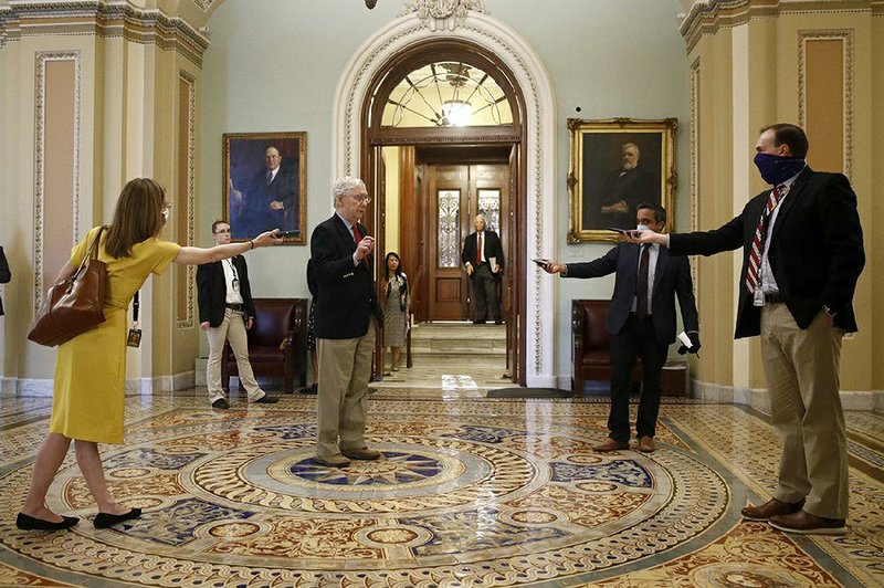 Senate Majority Leader Mitch McConnell speaks with reporters at a distance Thursday outside the Senate chamber. More photos at arkansasonline.com/410aid/.
(AP/Patrick Semansky)