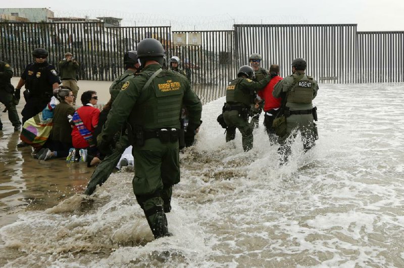 Border Patrol agents (right) detain a man during a protest in San Diego near the border with Tijuana, Mexico, in 2018.
(AP/Gregory Bull)
story.lead_photo.caption
