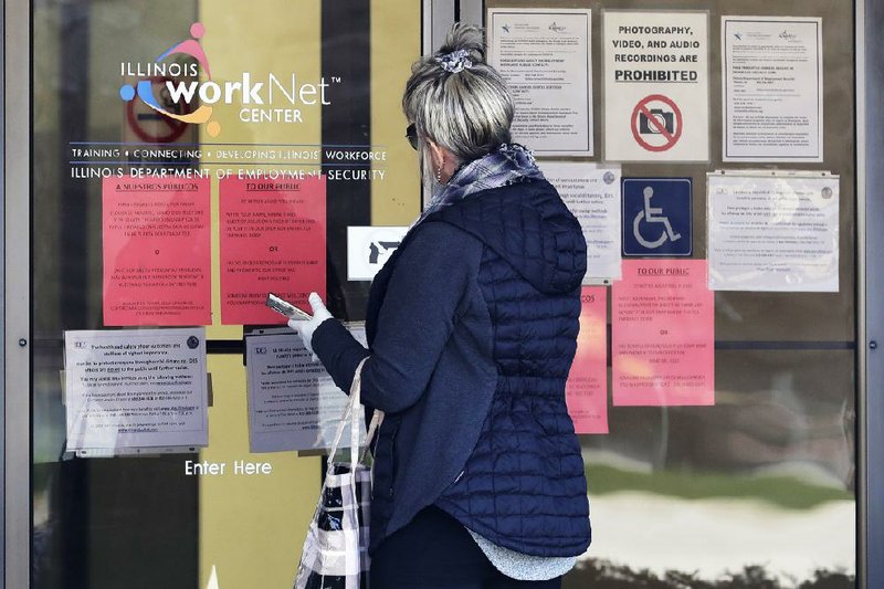 A woman checks job application information at a state unemployment office Thursday in Arlington Heights, Ill. Another 6.6 million people fi led for unemployment benefits in the past week, federal officials said Thursday. More photos at arkansasonline.com/410jobless/.
(AP/Nam Y. Huh)